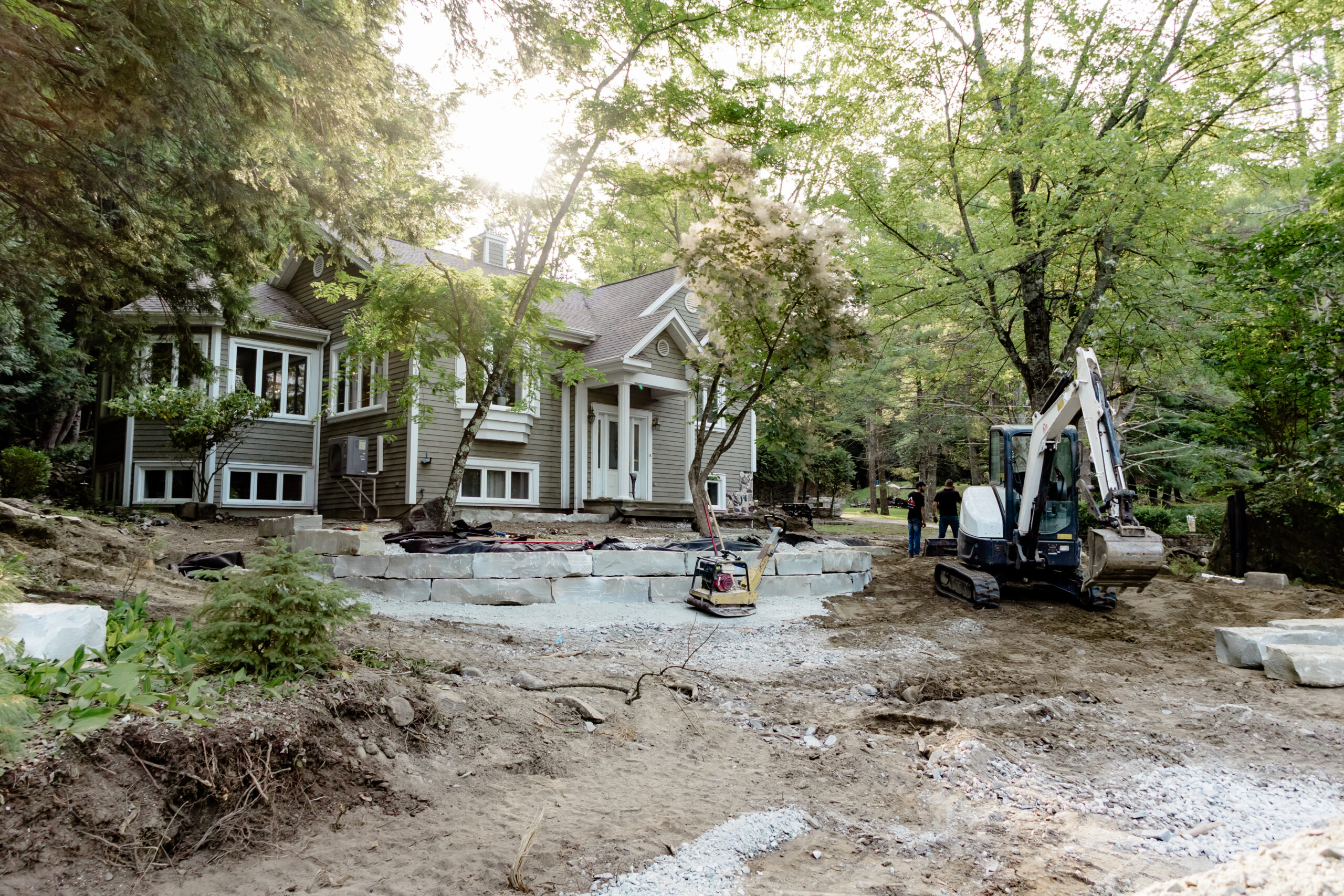 Terrain en préparation devant une maison avec mini-excavatrice