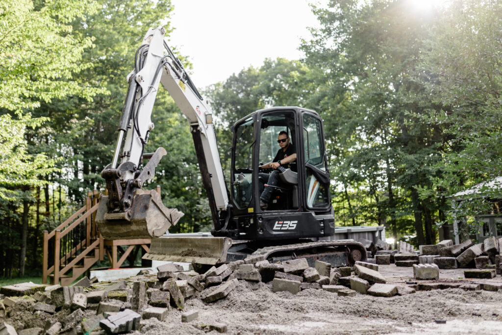 Mini-excavatrice qui démolit un ancien aménagement