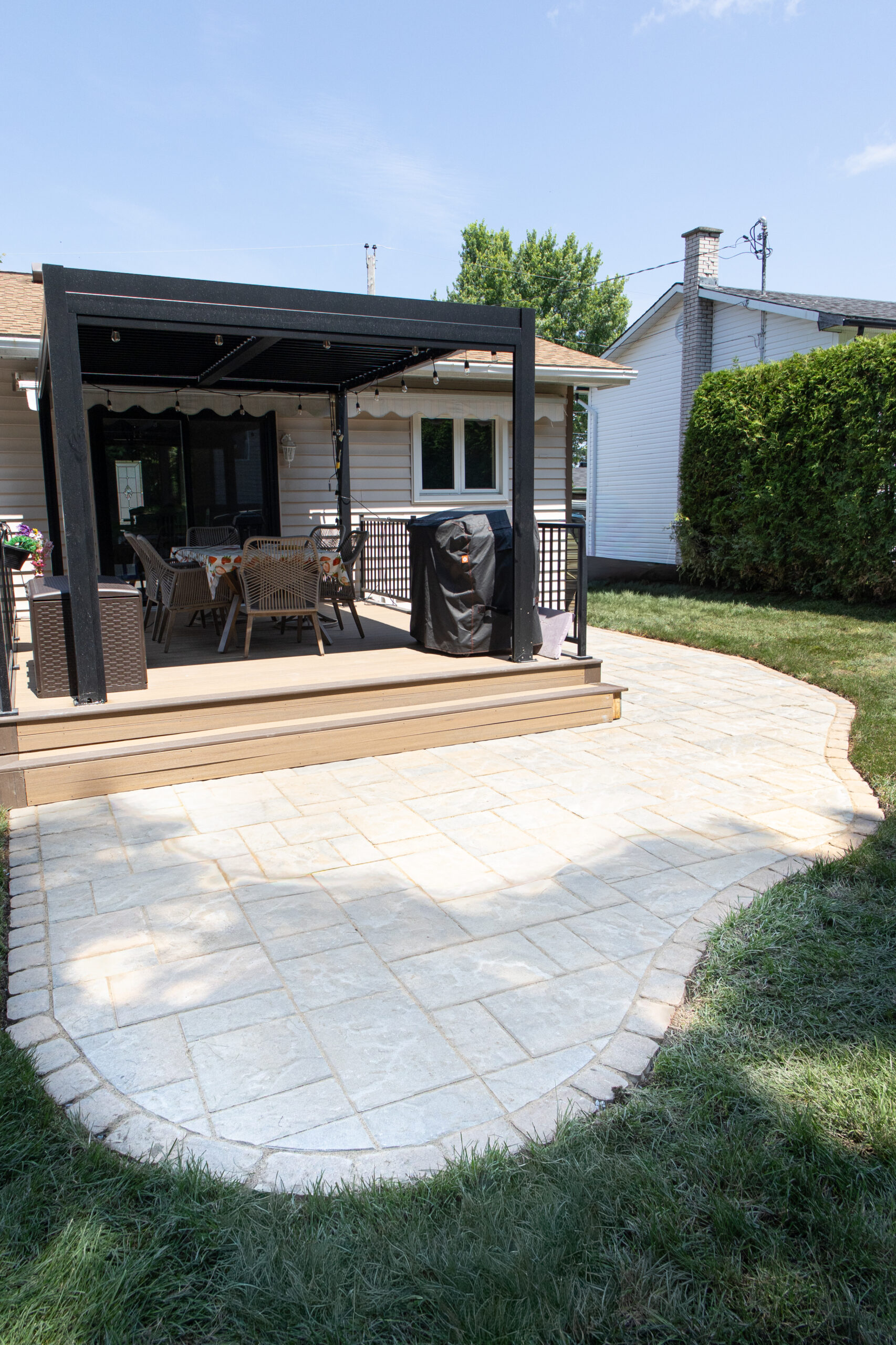 Patio en pavé uni aux contours courbes avec pergola