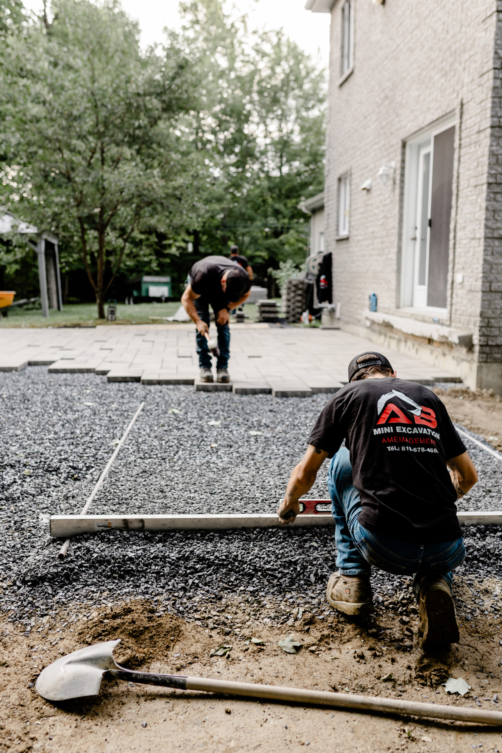 Équipe AB qui prépare une fondation de pavé