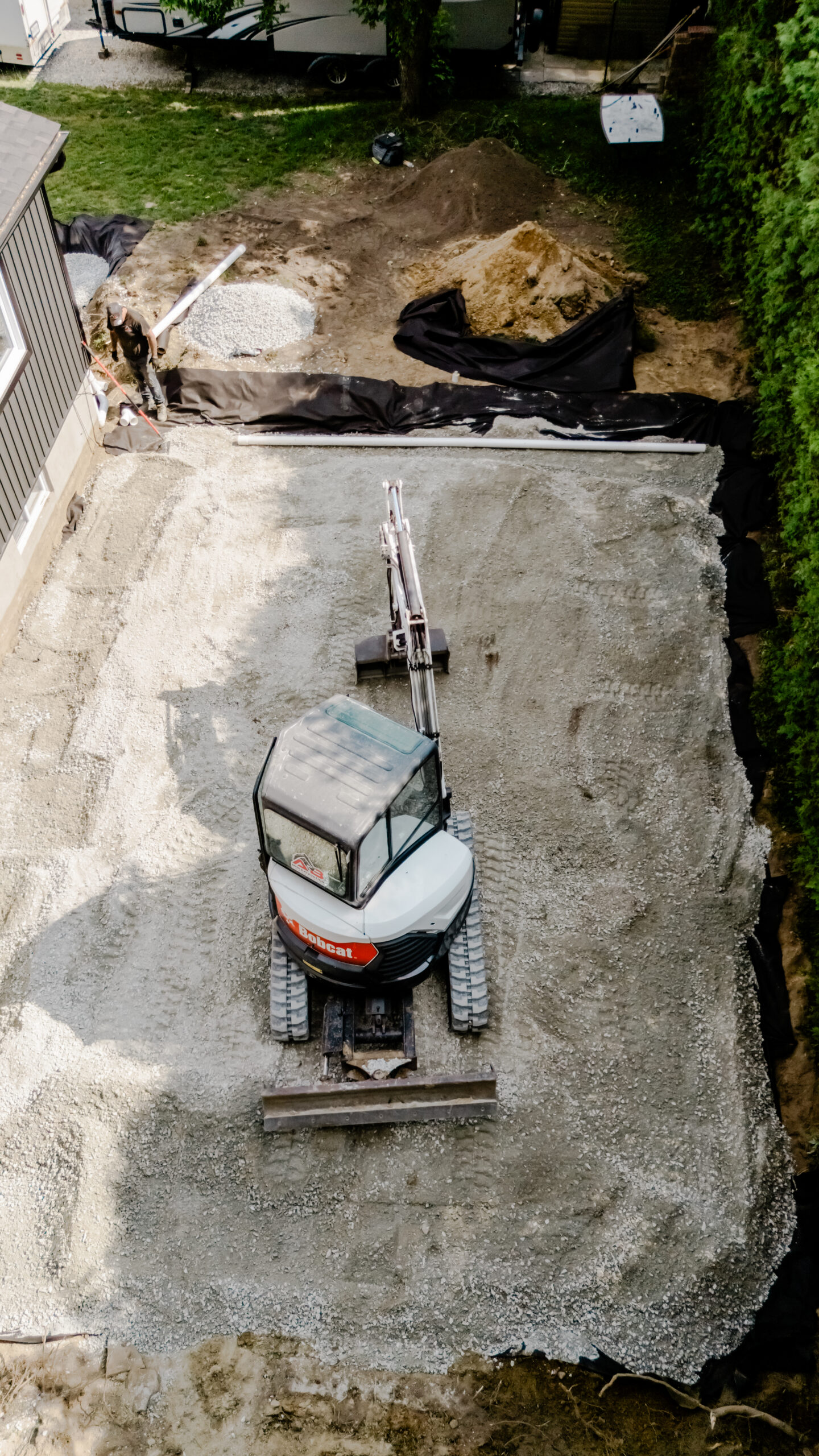 Fondation granulaire en préparation avec mini-excavatrice, vue du ciel