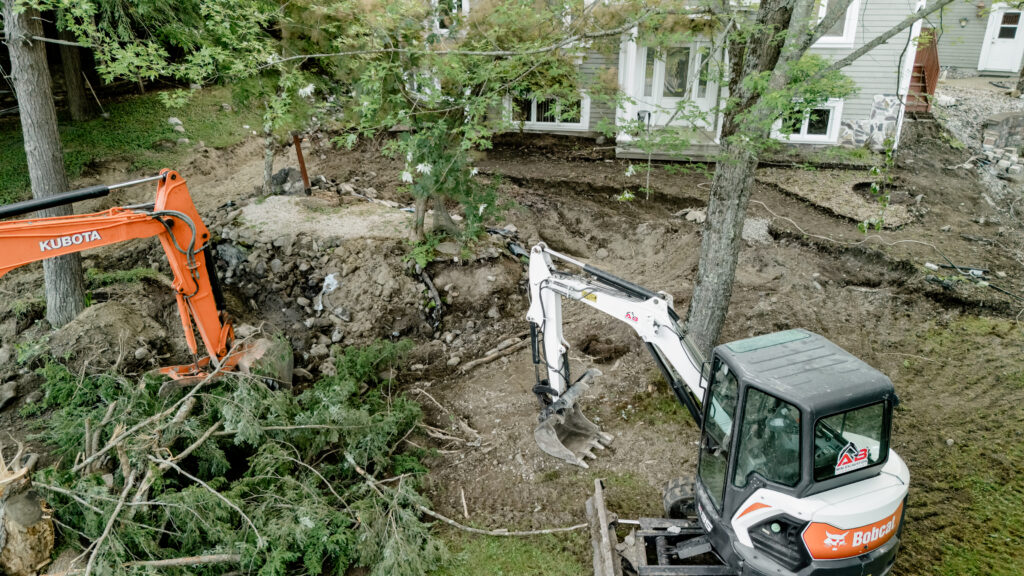 Deux excavatrices au travail dans une cour boisée