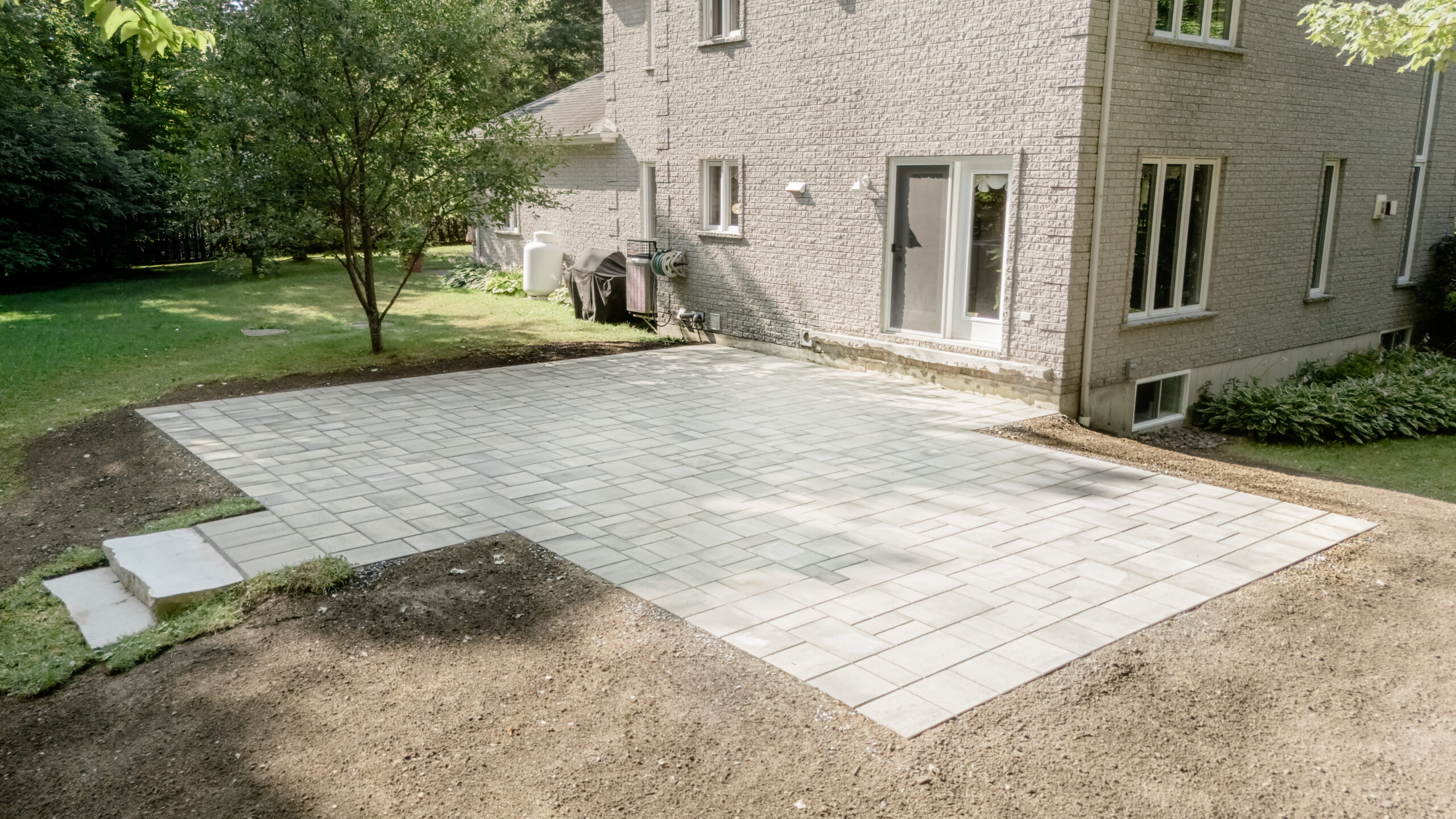 Patio en dalles de béton terminé derrière une maison