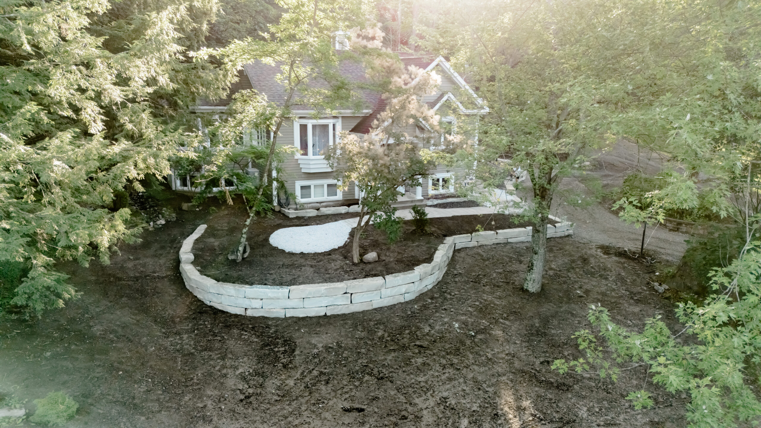 Terrain nivelé et muret courbe en façade